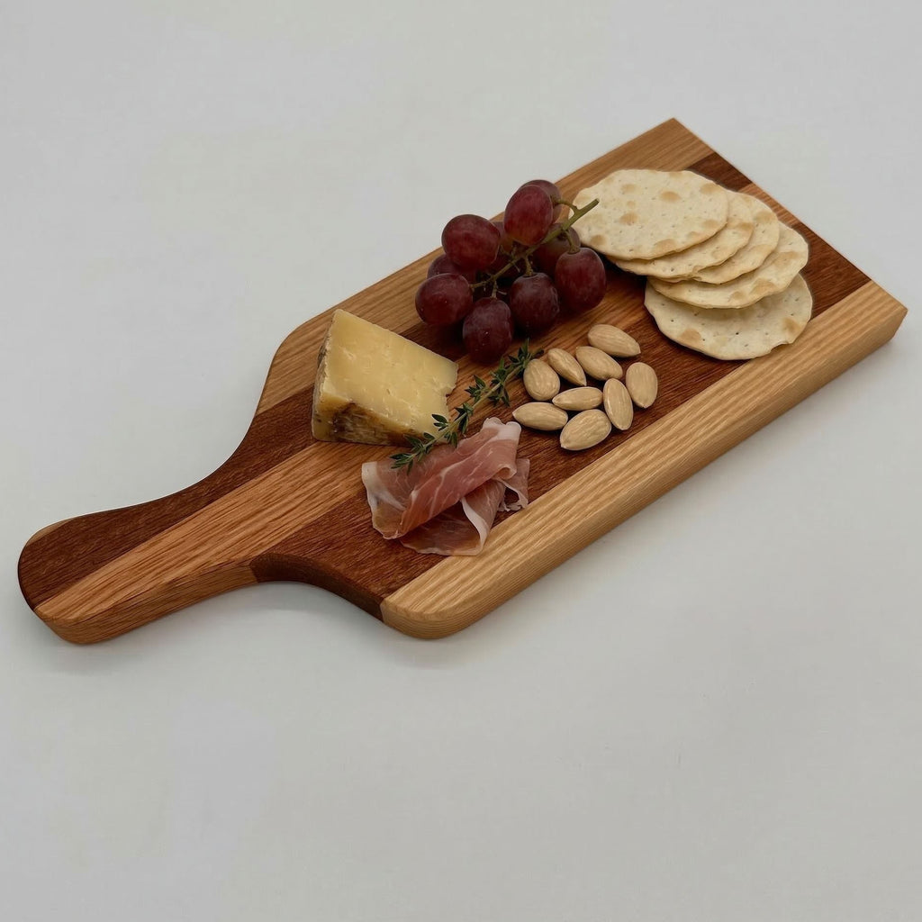 Wooden cutting board with cheese, grapes, prosciutto, almonds, and crackers on a white background
