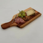 Wooden cutting board with salami, grapes, and cheese on a white background