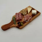 Wooden charcuterie board with cured meats, cheese, and olives on a white background