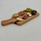 Wooden charcuterie board with assorted meats, cheeses, and fruits on a white background