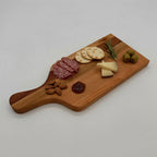 Wooden charcuterie board with salami, crackers, cheese, olives, and nuts on a white background