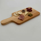 Wooden serving board with assorted food items on a light gray background