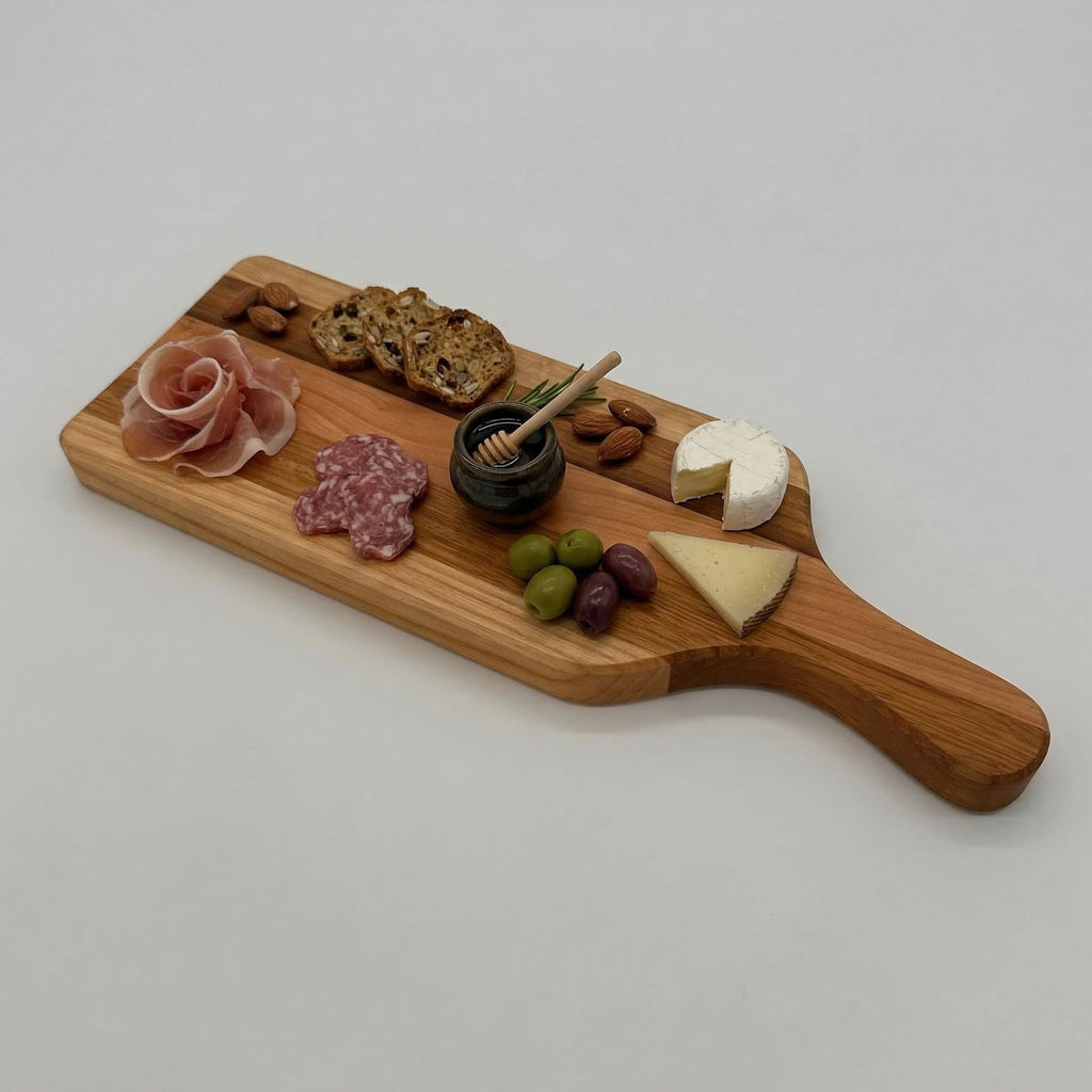 Wooden charcuterie board with cured meats, cheese, and fruits on a white background