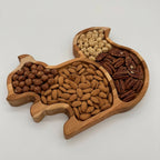 Wooden tray shaped like a squirrel filled with various nuts on a white background